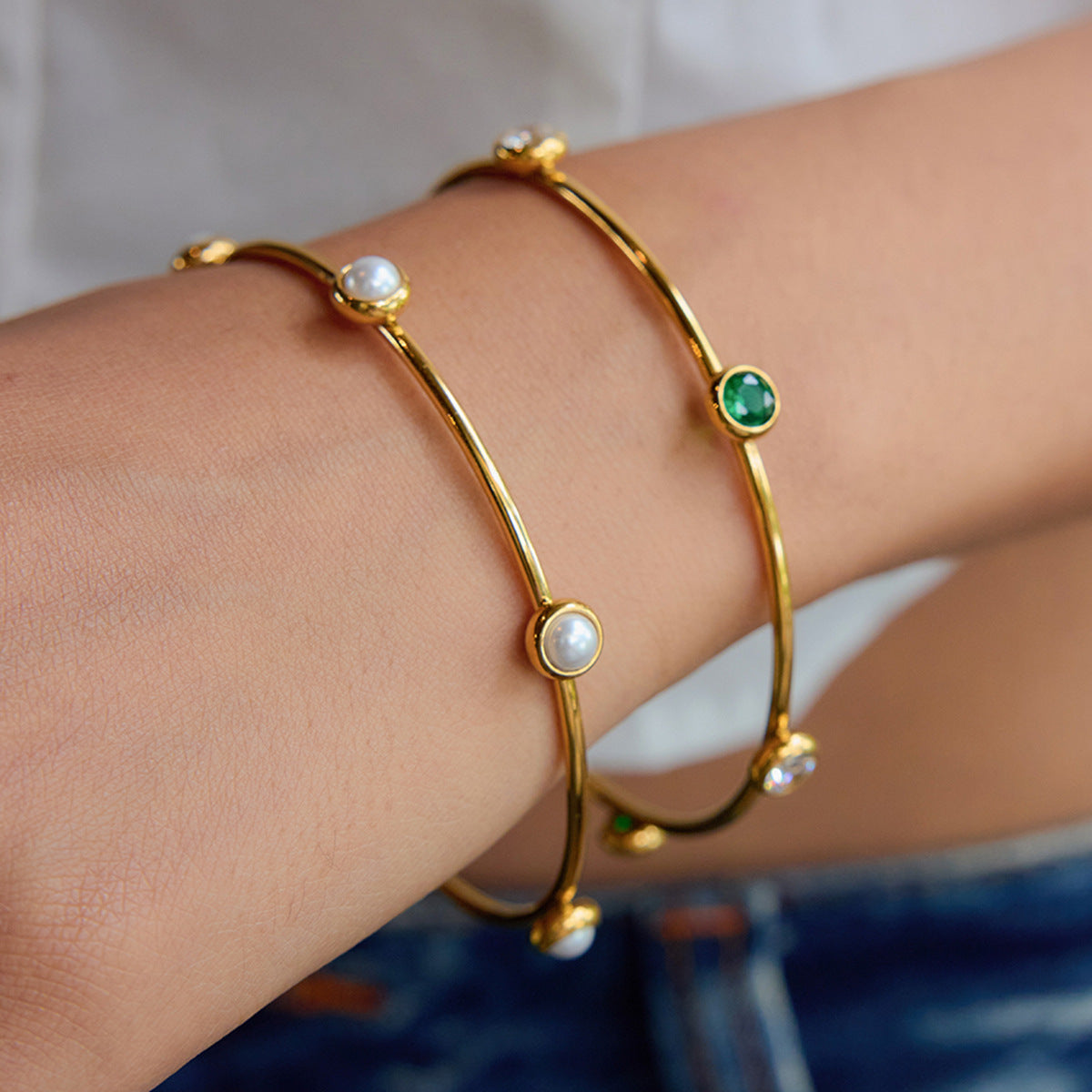 Model wearing minimalist gold bangle with pearls