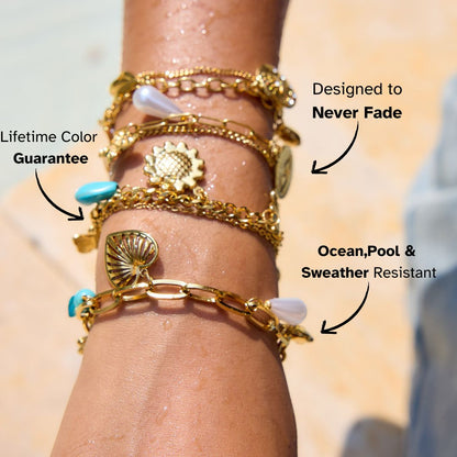 Multiple waterproof gold bracelets stacked on wet wrist, perfect for poolside or beach