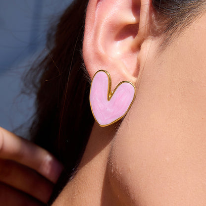 Close-up of pink heart earrings on model under sunlight