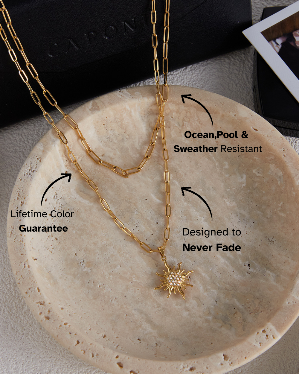 Gold chain necklace on a stone surface with text about features.