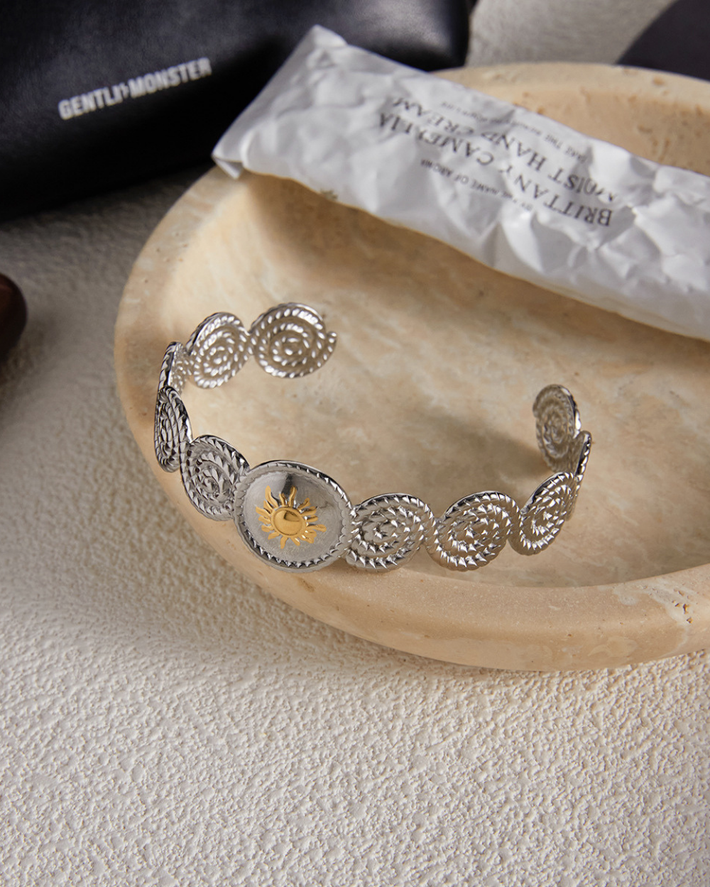Silver headband with intricate designs on a wooden surface