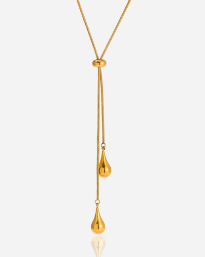 Gold necklace with a teardrop pendant on a white background