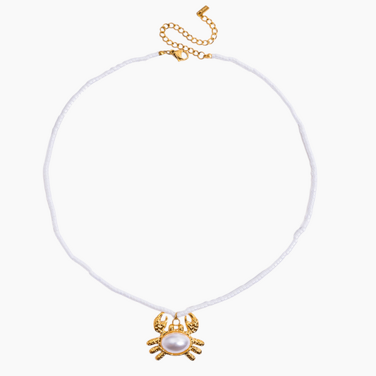 White choker necklace with gold spider charm on a white background