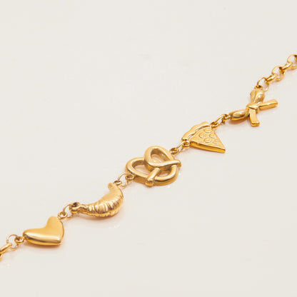 Fun gold bracelet with heart, croissant, pretzel, pizza, and bow charms