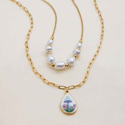 Artistic back view of mushroom charm with gold teardrop backplate, paired with pearls