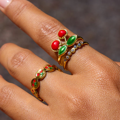 Model wearing cherry rings with colorful accents against beach background