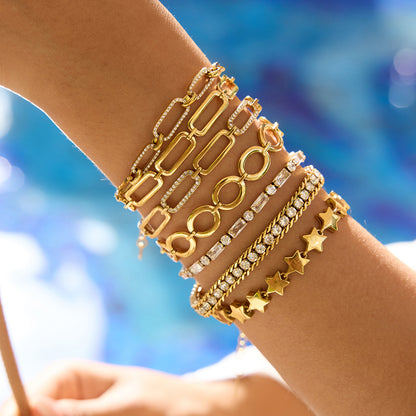 White crystal bracelet layered with gold bangles on model's wrist_MiFJewelry