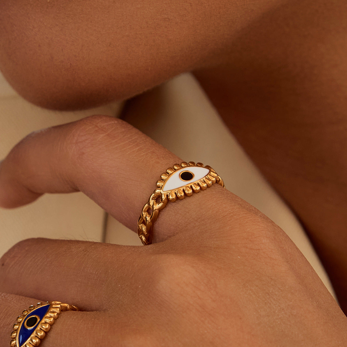Model hand close-up with white enamel evil eye ring