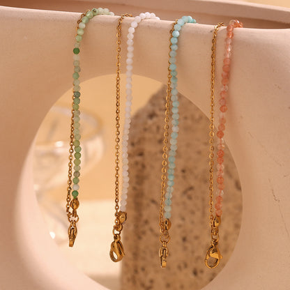 Spring tone bracelet set featuring pastel white and mint green gemstones on warm-toned props.