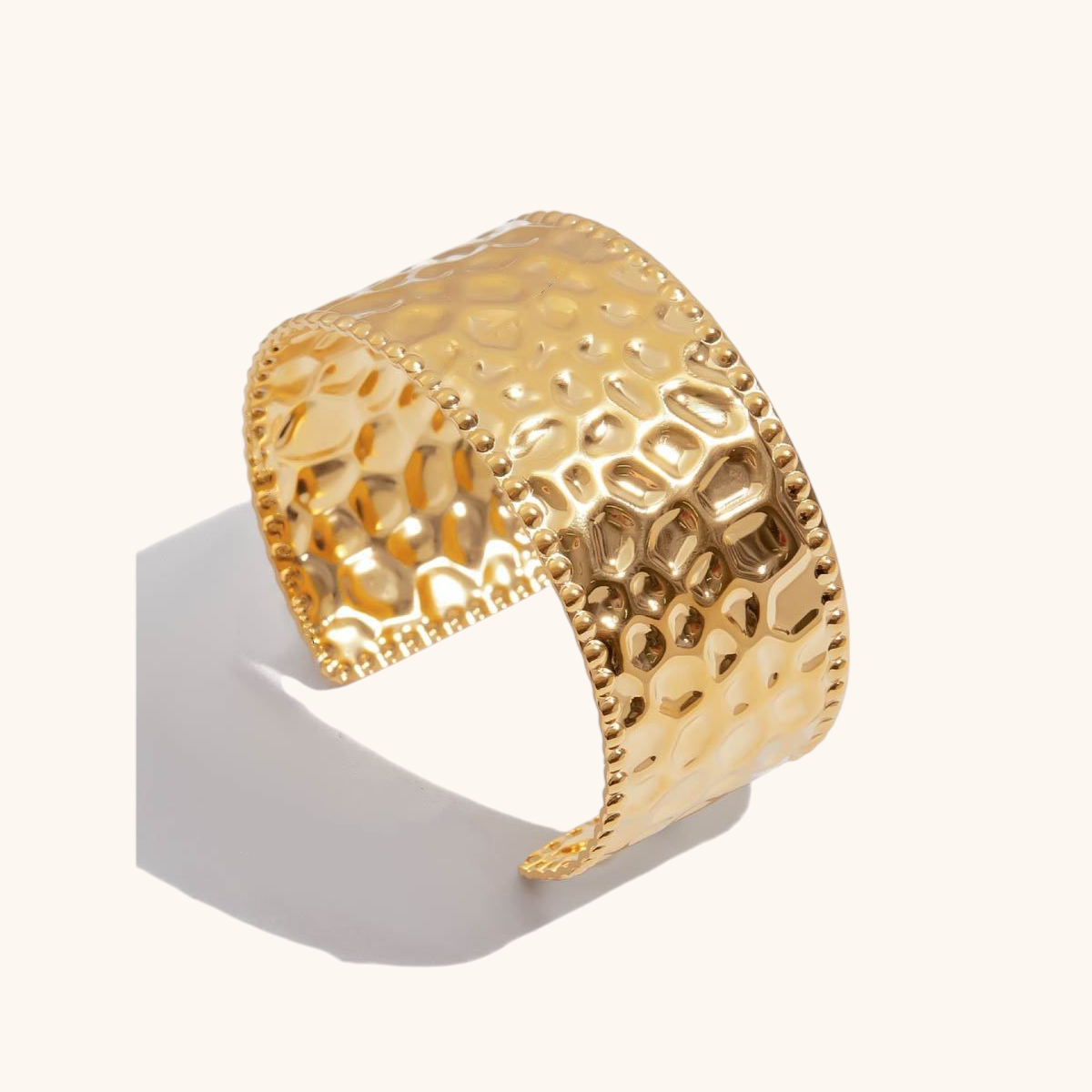 Studio shot of bold waterproof textured cuff bracelet in shiny gold finish