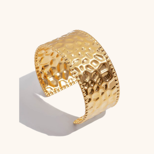 Studio shot of bold waterproof textured cuff bracelet in shiny gold finish