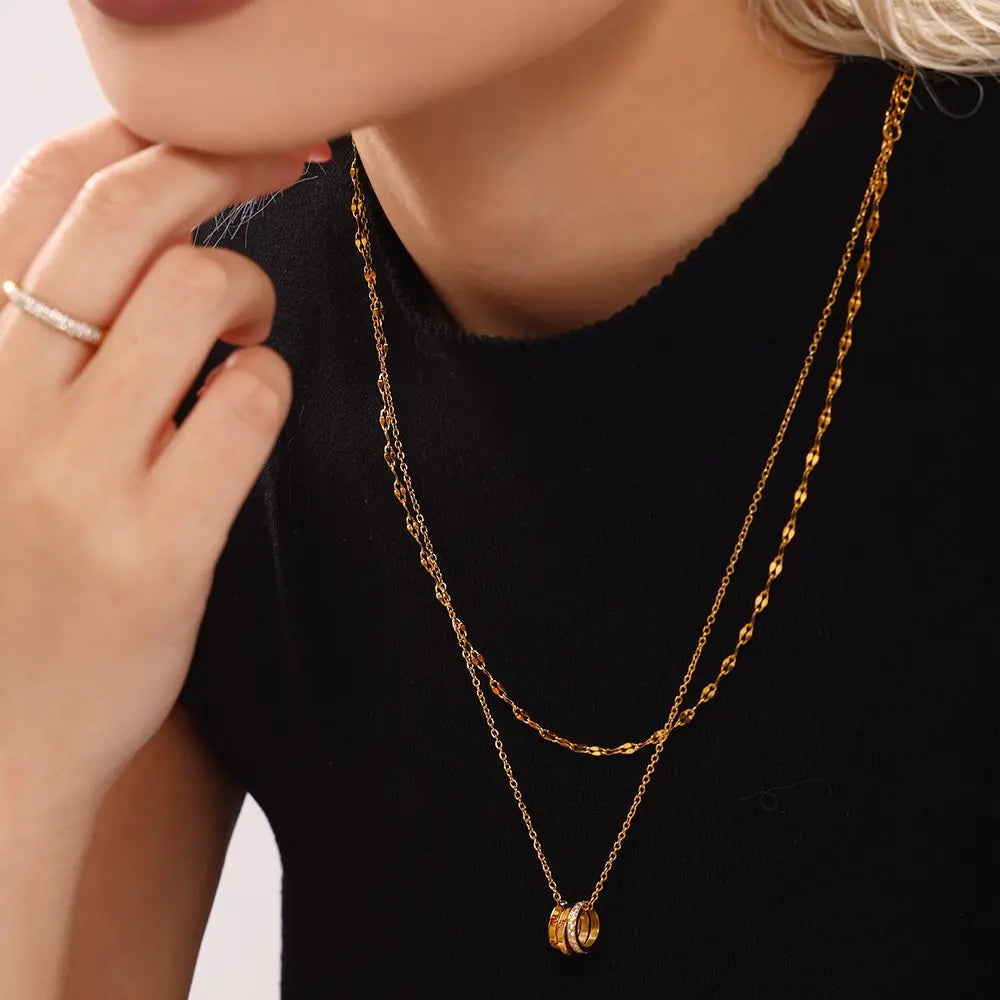 Model wearing the 'With Love' Triple Ring Necklace with multicolor zircon stones, styled elegantly with a turtleneck.