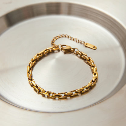 Gold link bracelet displayed in round silver dish, highlighting waterproof and fade-resistant design