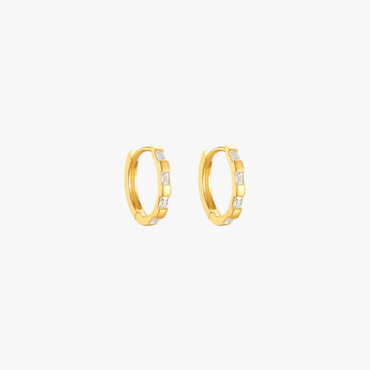 Gold huggie earrings featuring baguette diamonds, ideal for adding a touch of luxury.
