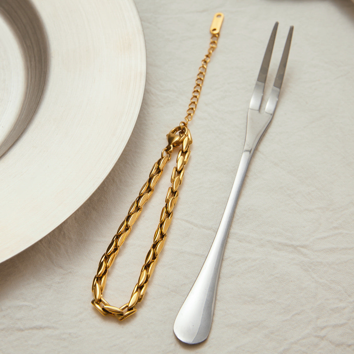 Simple 18K gold-plated bracelet with shine, styled with tableware for minimalist charm