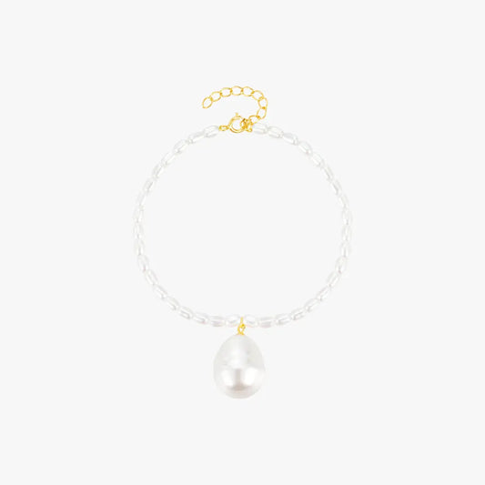 Minimalist pearl bracelet with a gold clasp and baroque pearl charm, adding sophistication to any outfit.